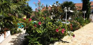 un jardín con flores rosas en una acera de ladrillo en Paradise-Garden-Zamardi, en Zamárdi