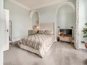 een witte slaapkamer met een bed en een televisie bij Temperance House in Selby