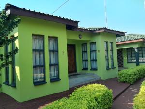 ein grünes Haus mit schwarzen Fenstern in der Unterkunft RS GARDEN GUESTHOUSE in Thohoyandou