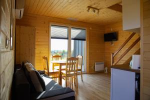 a living room with a table and chairs in a cabin at Zielona Osada in Ciężkowice