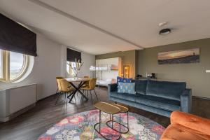 a living room with a couch and a table at Leonardo Hotel IJmuiden Seaport Beach in IJmuiden