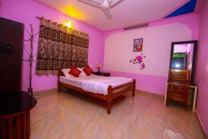 um quarto com paredes cor-de-rosa e uma cama num quarto em Mount view Holidays em Vagamon