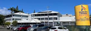 a parking lot with cars parked in front of a building at Karaibes Hotel in Le Gosier
