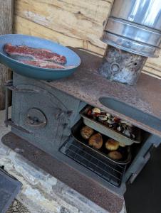 a stove with a hot dog and a pan on top at Shirehill Farm in Chippenham