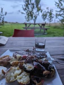 a plate of food on a table with a glass of wine at Shirehill Farm in Chippenham