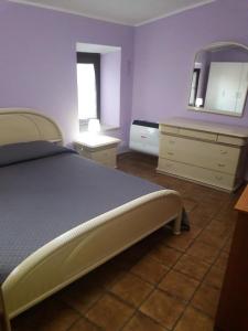 1 dormitorio con cama, tocador y espejo en Casetta Santa Maria, en Subiaco