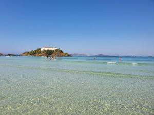 a beach with a house on an island in the water at AP encantador na Praia do Forte! Porto Azul (107) in Cabo Frio