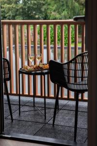 a table with two chairs and wine glasses on a balcony at Bed & Breakfast Bellesza in Oldeberkoop