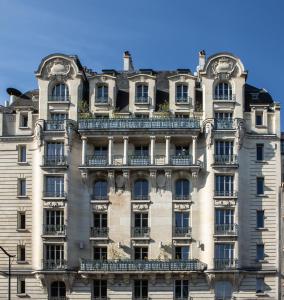 パリにあるHotel Flanelles Parisのバルコニー付きの大きな建物