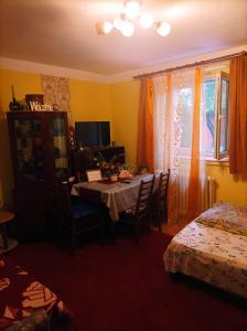 uma sala de jantar com uma mesa com cadeiras e uma janela em Locuința două dormitoare pt 3-4persoane em Cluj-Napoca