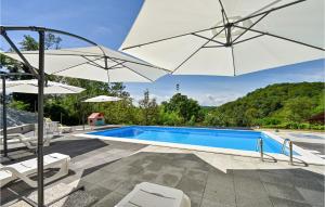 una piscina con 2 sombrillas y una piscina en Cozy Home In Martinkovec With Kitchen, en Varaždinske Toplice