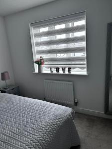 a bedroom with a white bed and a window at Double Room in a Family Home - 15 Minutes Walk to Famous Bicester Village in Chesterton