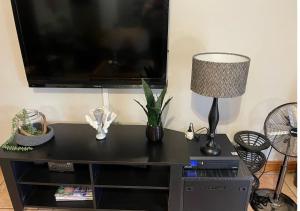 un tavolo nero con lampada e TV a schermo piatto di Nonna's Cottage a Durban