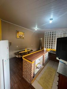 a kitchen with a counter top and a refrigerator at AMPLO SOBRADO BEM NO CENTRO, faça tudo a PÉ! in São Bento do Sapucaí