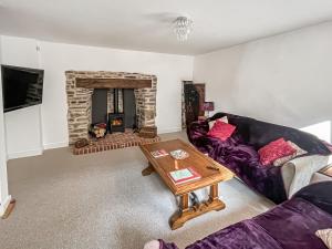 a living room with a couch and a fireplace at Victoria House in Chulmleigh