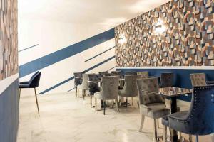 a row of tables and chairs in a restaurant at Hôtel Center Saint-Quentin Centre Gare 24-24 Parking privé in Saint-Quentin