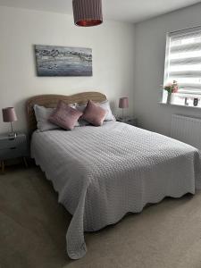a bedroom with a large white bed with pillows at Double Room in a Family Home - 15 Minutes Walk to Famous Bicester Village in Chesterton