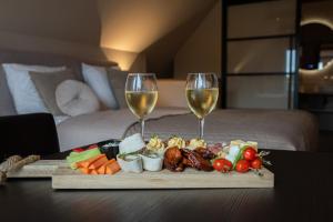 - un plateau de nourriture et 2 verres de vin sur une table dans l'établissement Bed & Breakfast Bellesza, à Oldeberkoop