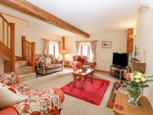 a living room with a couch and a tv at 2 Stud Cottage in Hainford
