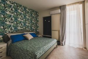 a bedroom with a bed with a green and white blanket at Casa Dolce Casa in Orvieto