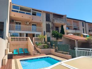 an apartment with a swimming pool in front of a building at Sur les hauteurs de Collioure in Collioure