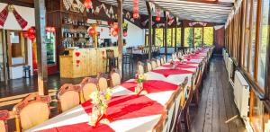 a row of tables in a restaurant with red napkins at Pensiunea Skiland in Muntele Băişorii