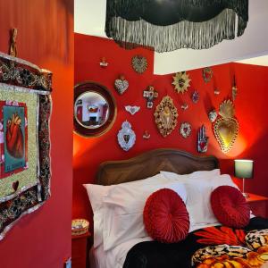 een slaapkamer met rode muren en een bed met rode kussens bij Frida's Cottage Whitby in Whitby
