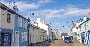 une rue avec drapeaux et bâtiments dans une ville dans l'établissement Lovely two bed home in Cemaes, Anglesey, à Baie de Cemaes