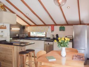 a kitchen with a table with a vase of flowers on it at Woodlands Lodge in Colmonell