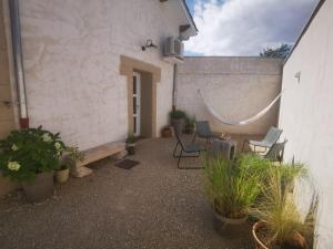 a patio with chairs and plants next to a building at Le Petit Saugnieu in Colombier-Saugnieu