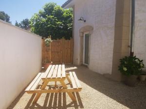 un banc en bois installé à côté d'un bâtiment dans l'établissement Le Petit Saugnieu, à Colombier-Saugnieu