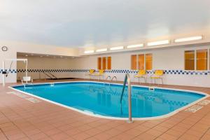 una grande piscina in una camera d'albergo con sedie gialle intorno di Fairfield Inn & Suites Minneapolis St. Paul/Roseville a Roseville