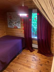 a bedroom with a purple bed and a window at Rauhallinen mökki luonnon keskellä. in Orivesi
