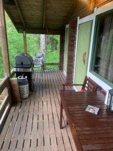 eine abgeschirmte Veranda mit einem Grill und einem Picknicktisch in der Unterkunft Rauhallinen mökki luonnon keskellä. in Orivesi