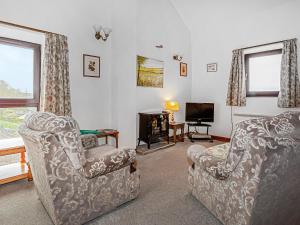 a living room with two chairs and a television at Jerusalem Cottage in Longnor