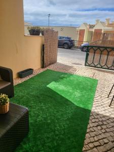 un parche de hierba verde artificial en un patio en MiaMar House Sesimbra en Sesimbra