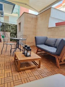 eine Terrasse mit einem Sofa, einem Tisch und Stühlen in der Unterkunft Iris Casa Vacanza in Noci
