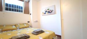 ミラノにあるElegant Sweet Home Suite - Milan, 15 minute Duomoのベッドルーム1室(黄色いシーツ付きのベッド1台、窓付)