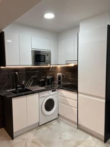 a kitchen with a washing machine and a microwave at BENILOVE en PLAYA OFFRE SPECIALE NOVEMBRE ET DECEMBRE Vue Mer Panoramique in Benidorm