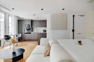 een woonkamer met een witte bank en een keuken bij Brand New Modern Studio in Central Paris - 2P - B1 in Parijs