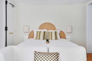 een witte slaapkamer met een groot wit bed met 2 kussens bij Brand New Modern Studio in Central Paris - 2P - B1 in Parijs