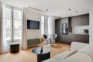 een woonkamer met een witte bank en een keuken bij Brand New Modern Studio in Central Paris - 2P - B1 in Parijs