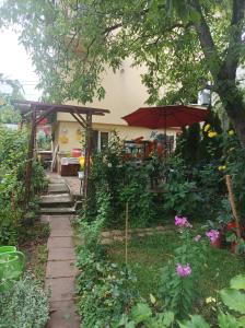 uma casa com um pátio com um guarda-chuva e flores em Locuința două dormitoare pt 3-4persoane em Cluj-Napoca