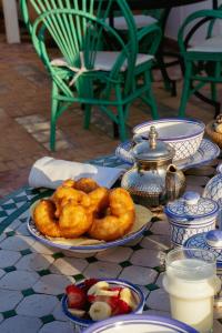einen Teller mit Zwiebelringen und Obst auf dem Tisch in der Unterkunft Villa Maroc Essaouira in Essaouira