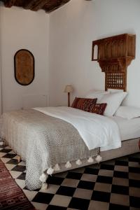 um quarto com uma cama grande e piso em xadrez em Villa Maroc Essaouira em Essaouira