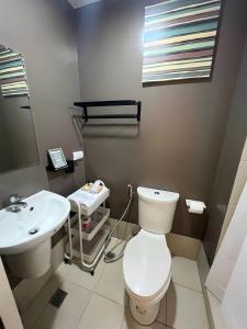 a bathroom with a white toilet and a sink at Suēlo at Cool Suites at Wind Residences Tagaytay in Tagaytay