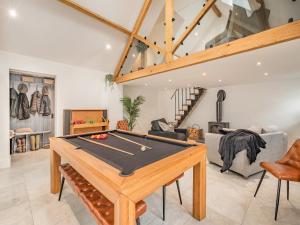a living room with a ping pong table at Ysgubor Caemai in Bangor-is-y-coed