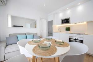 a living room with a white table and a kitchen at APARTAMENTOS CARMEN in Maro