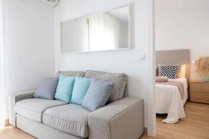 a living room with a couch and a mirror at APARTAMENTOS CARMEN in Maro