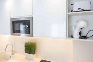 a kitchen with a microwave oven above a sink at APARTAMENTOS CARMEN in Maro